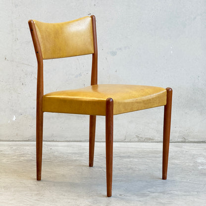 A set of six mid-century modern Parker Number 97 Dining Chairs in original mustard vinyl upholstery, shown on a concrete floor against a plain light gray wall.