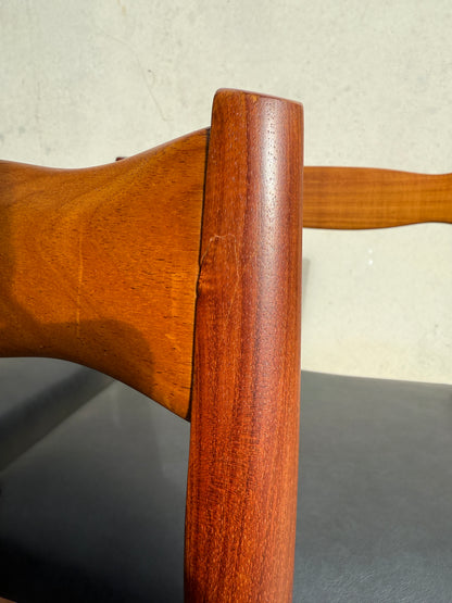 Close-up of a wooden armrest on a Fully Restored Fler 64 Dining Chair from the Set of 6 – Liquorice Vinyl (Rediscover), showing smooth finish, wood grain, and a minor scratch. The chair features a liquorice vinyl seat in mid-century modern style.