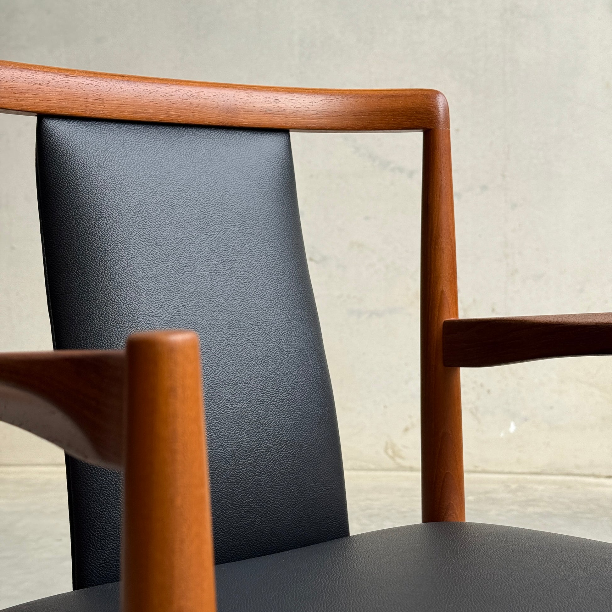 Close-up of the Pre-Order: Professional Restoration of Parker 89 Chair, featuring a wooden frame and black commercial-grade vinyl upholstery on the backrest and seat; 25% non-refundable deposit required.