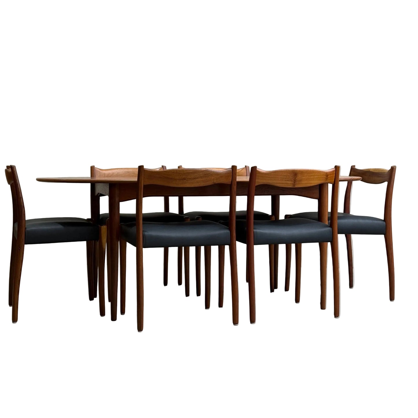 A fully restored mid-century Parker 91 oval teak dining suite with six Fler 64 blackwood chairs (Rediscover), styled against a minimalist concrete wall and floor.