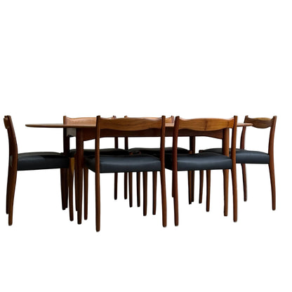 A fully restored mid-century Parker 91 oval teak dining suite with six Fler 64 blackwood chairs (Rediscover), styled against a minimalist concrete wall and floor.