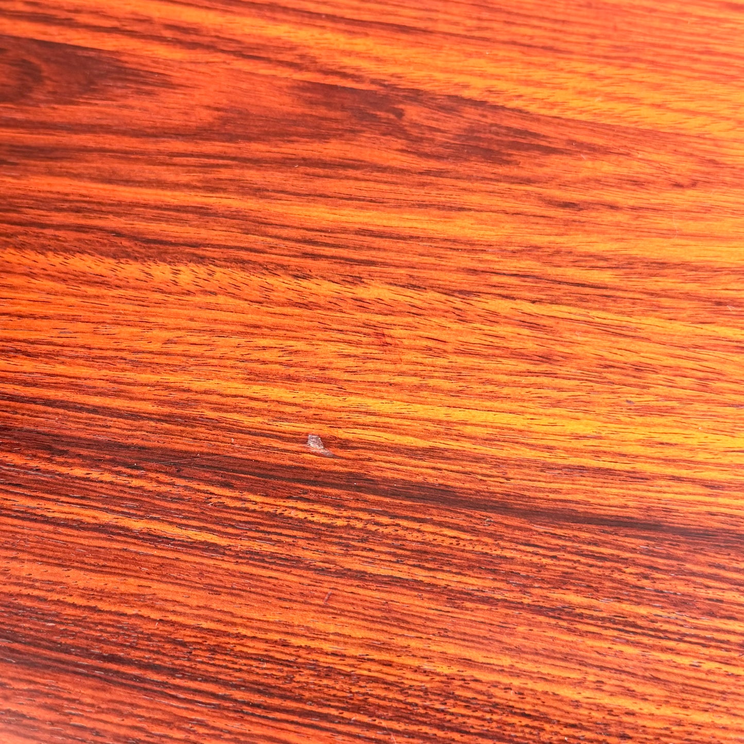 A close-up of a 1970s Danish Modern Rosewood Dropleaf Dining Table by Vejle Stole og Mobelfabrik (Model 166, 1975) shows orange and brown grain with a small chip near the center, indicating minor wood damage.