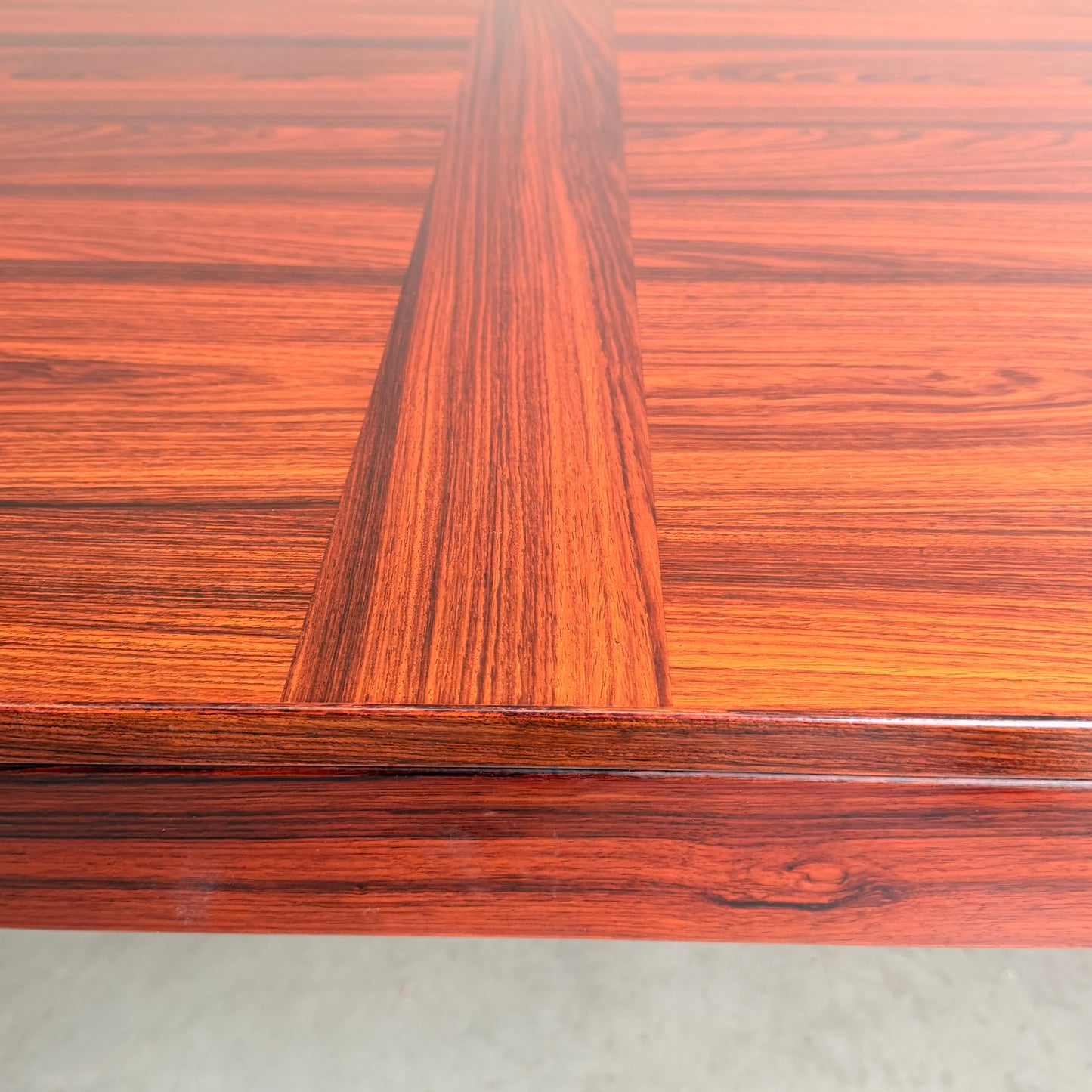 Close-up of a 1970s Danish Modern Rosewood Dropleaf Dining Table (Model 166, 1975) by Vejle Stole og Mobelfabrik, highlighting its rich reddish-brown finish, striking wood grain, and refined geometric craftsmanship.