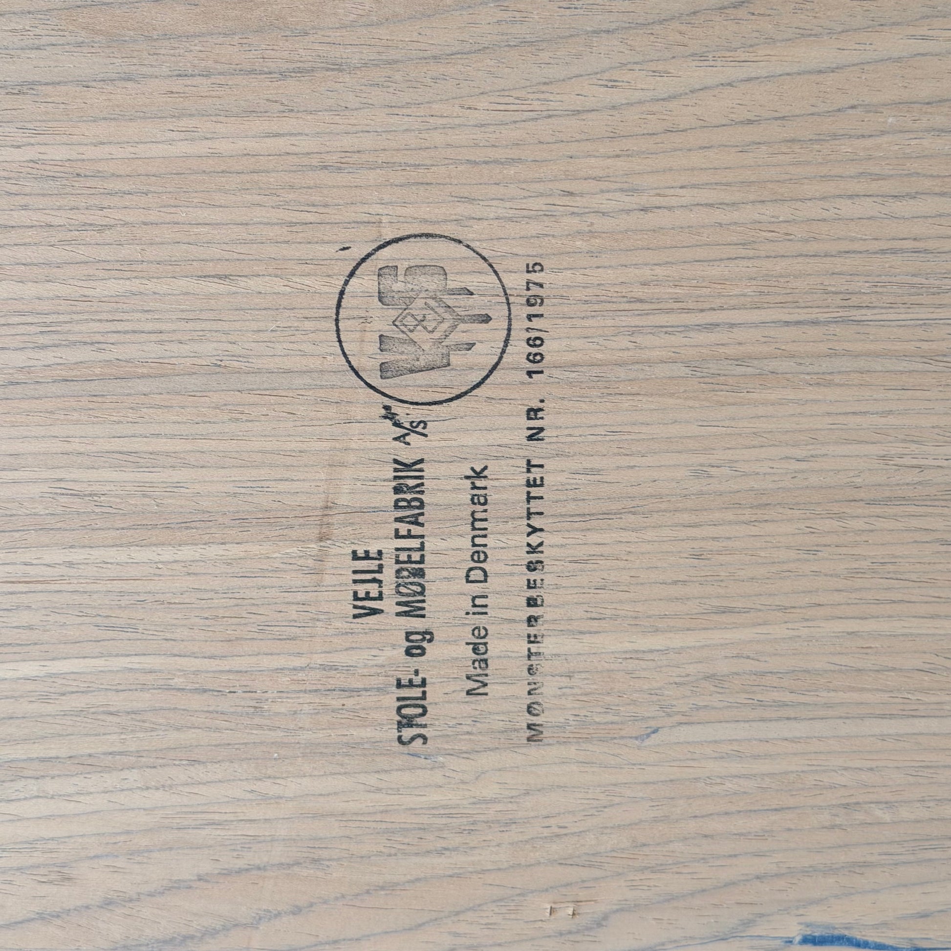 Close-up of a wooden surface stamped with "Vejle Stole og Mobelfabrik, Made in Denmark"—the hallmark found on this 1970s Danish Modern Rosewood Dropleaf Dining Table (Model 166, 1975).