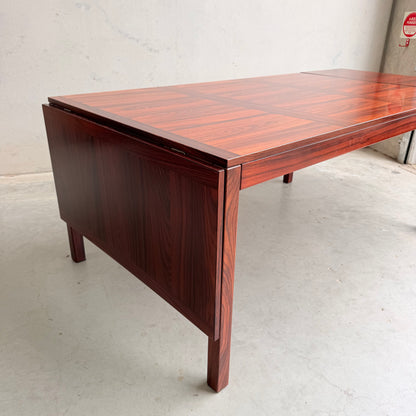 The 1970s Danish Modern Rosewood Dropleaf Dining Table by Vejle Stole og Mobelfabrik (Model 166, 1975) features a rich, reddish-brown finish and drop-leaf extension, perfectly capturing classic mid-century Danish design.