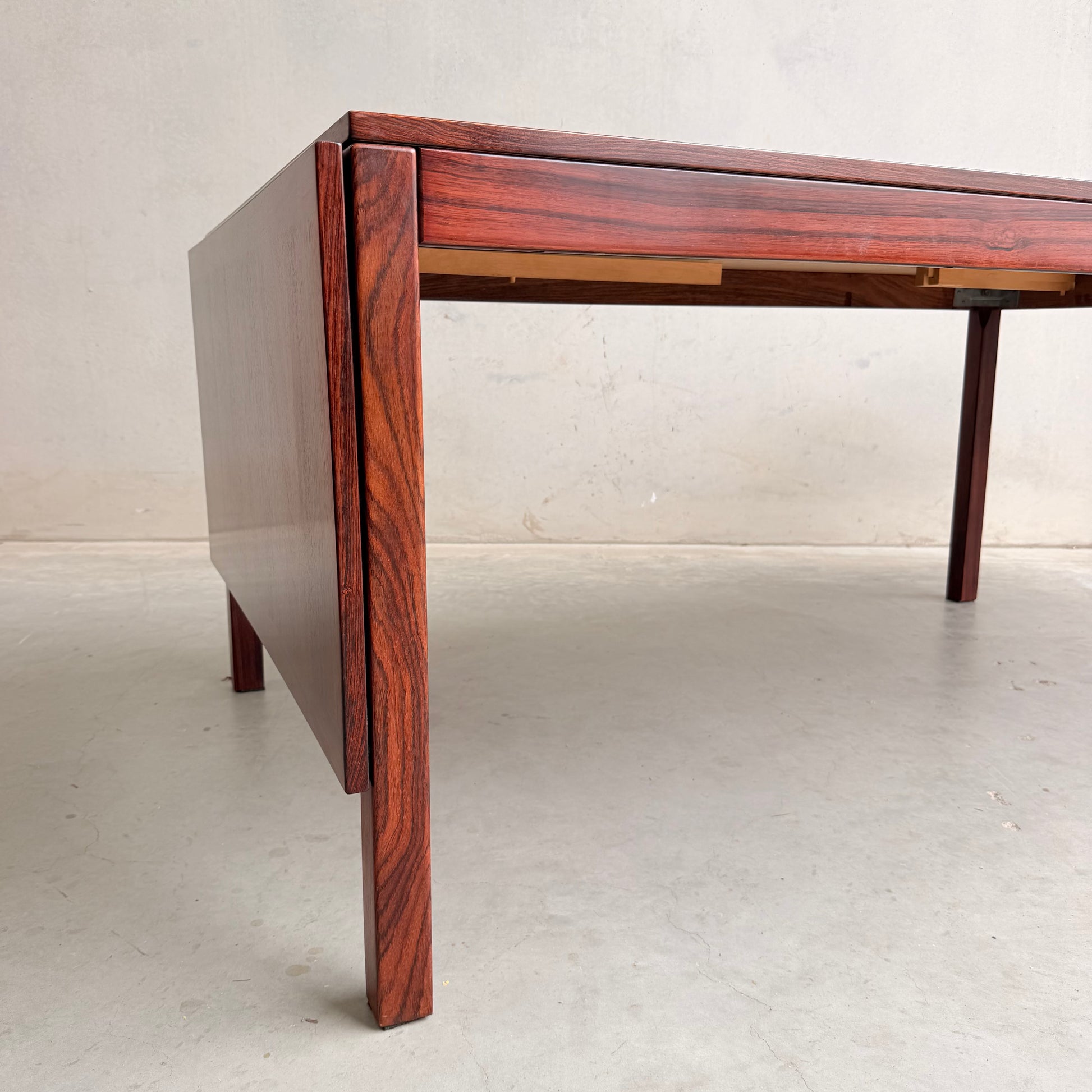 A close-up of a 1970s Danish Modern Rosewood Dropleaf Dining Table by Vejle Stole og Mobelfabrik (Model 166, 1975) highlights its clean lines, rich reddish-brown wood grain, and iconic rectangular leg design.
