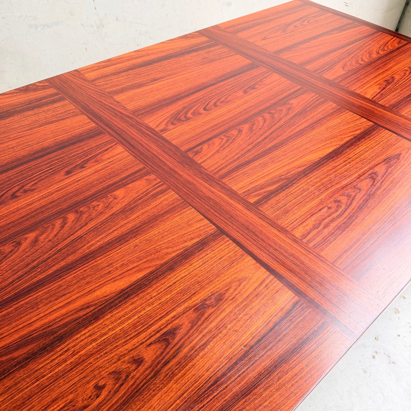 A close-up of the 1970s Danish Modern Rosewood Dropleaf Dining Table by Vejle Stole og Mobelfabrik (Model 166, 1975), featuring a reddish-brown polished finish, cross-patterned grain, and classic mid-century Danish design.