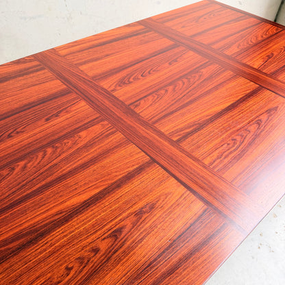 A close-up of the 1970s Danish Modern Rosewood Dropleaf Dining Table by Vejle Stole og Mobelfabrik (Model 166, 1975), featuring a reddish-brown polished finish, cross-patterned grain, and classic mid-century Danish design.