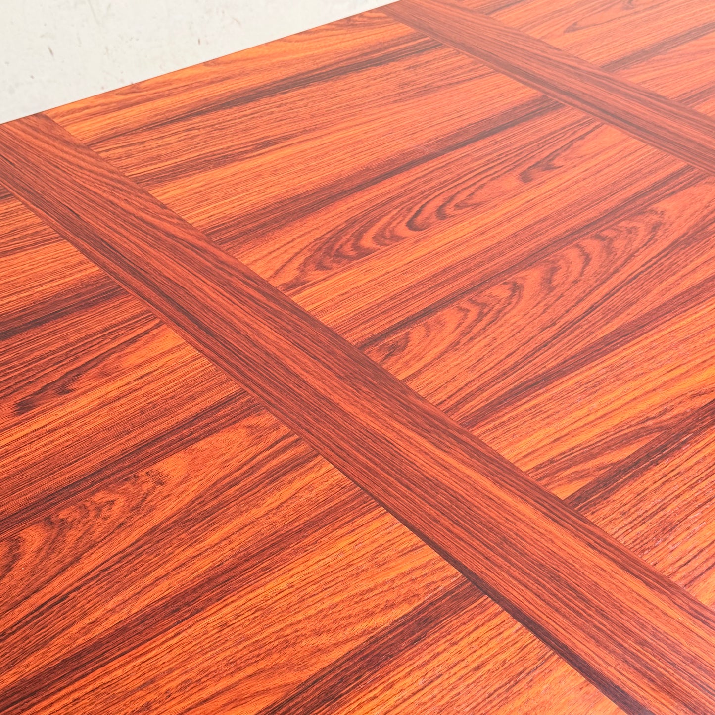 A close-up of the 1970s Danish Modern Rosewood Dropleaf Dining Table (Model 166, 1975) by Vejle Stole og Mobelfabrik shows its rich reddish-brown tone, visible grain, and signature inlaid grid pattern—classic mid-century Danish design.
