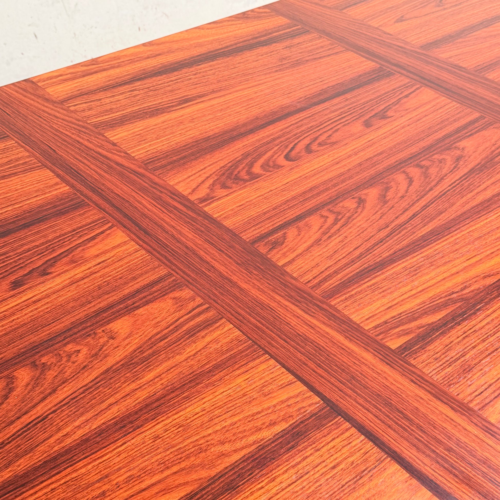 A close-up of the 1970s Danish Modern Rosewood Dropleaf Dining Table (Model 166, 1975) by Vejle Stole og Mobelfabrik shows its rich reddish-brown tone, visible grain, and signature inlaid grid pattern—classic mid-century Danish design.