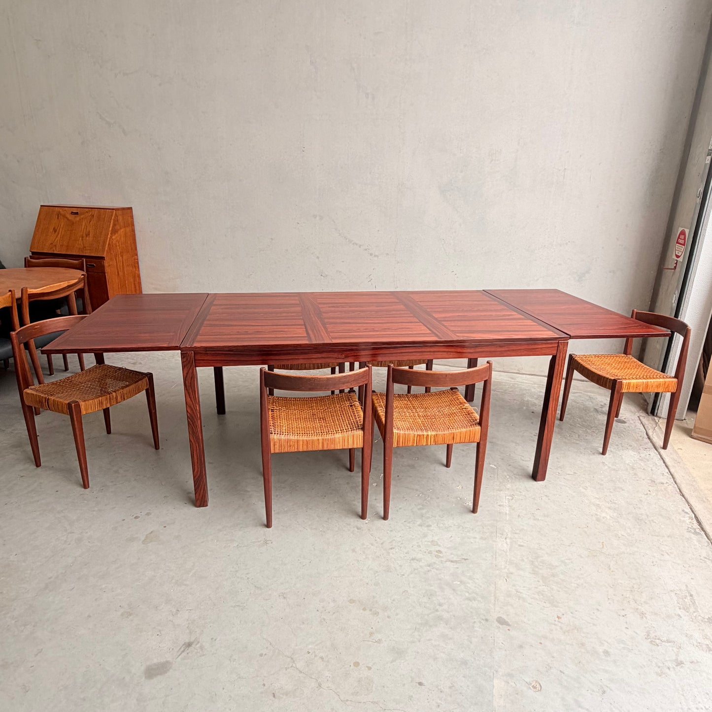 A 1970s Danish Modern rosewood dropleaf dining table by Vejle Stole og Mobelfabrik (Model 166, 1975) sits in a minimalist room, evoking classic mid-century Danish design.