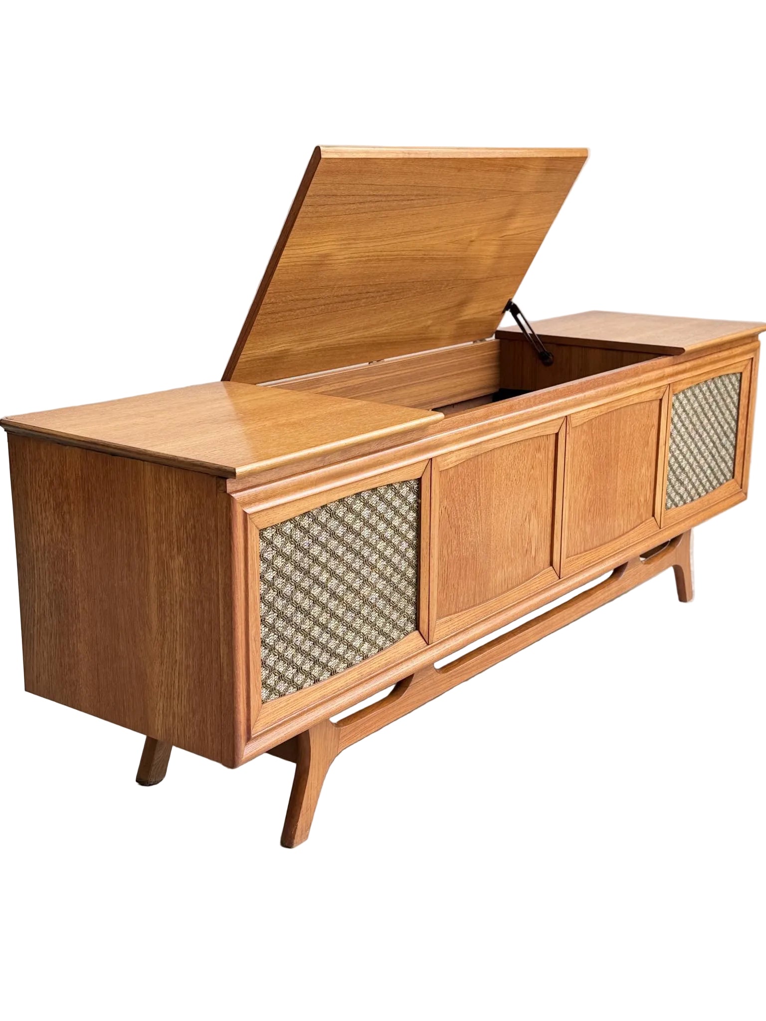The General Electric Credenza - Spacemaker 250 is a fully converted teak TV and entertainment console with book-matched panels, angled legs, textured front design, and a hinged lid revealing storage—shown on a plain concrete floor.