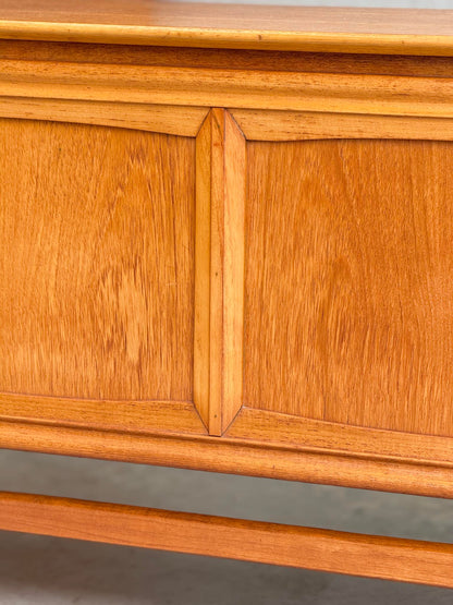 Close-up of the General Electric Credenza - Spacemaker 250, a fully converted teak TV/entertainment console, highlighting its warm honey-toned wood grain and smooth finish with a mid-century modern decorative panel design.